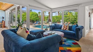 A modern living room with a blue sofa set, a coffee table, and a colorful rug.