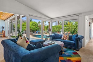A modern living room with a blue sofa set, a coffee table, and a colorful rug.
