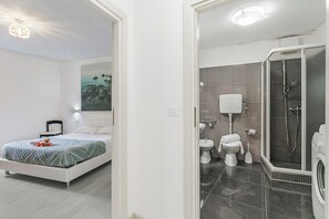 Departamento estándar, varias habitaciones (Piccola Torbole) | Baño | Regadera, secadora de cabello, toallas, jabón