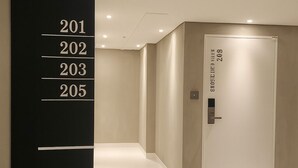 A modern hallway with a black sign displaying room numbers 201 to 205. - Seoul DDJ STAY (Seoul)