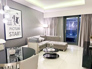 Deluxe appartement, uitzicht op stad | Woonruimte | Een 55-inch ledtelevisie met satellietzenders