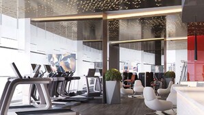 Un gimnasio moderno con cintas de correr, sillas de ejercicio y un amplio ventanal que proporciona luz natural.