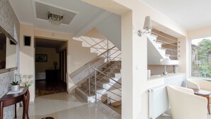 Moderni sisustus, jossa on portaikko, ruokailutila ja näkymä ikkunasta.