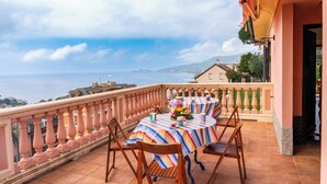 A balcony with a table set for two, overlooking a coastal view. - Charming 3-bedroom 4 bathrooms villa with WiFi and AC in beautiful Rapallo (Rapallo)