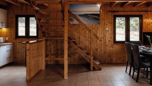 Een houten interieur met een trap, een eethoek en een keuken.