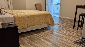 A bedroom with a bed, a desk, and a chair. There is a door leading to a balcony. - estudio proyector (Marietta)