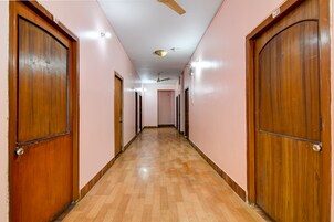 Un pasillo con puertas de madera, ventilador de techo e iluminación empotrada.