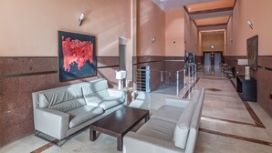A spacious lobby with a modern design, featuring a sofa, a coffee table, and a large abstract painting on the wall. - Cozy home with terrace and access to swimming pool! (Las Palmas)