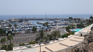 A marina with boats docked, a road, and a pool area. - Cozy home with terrace and access to swimming pool! (Las Palmas)