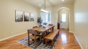 A dining area with a wooden table and benches, a chandelier, and framed artwork on the wall. - Tasteful Flagstaff Townhome w/ 2 Furnished Decks (Flagstaff)