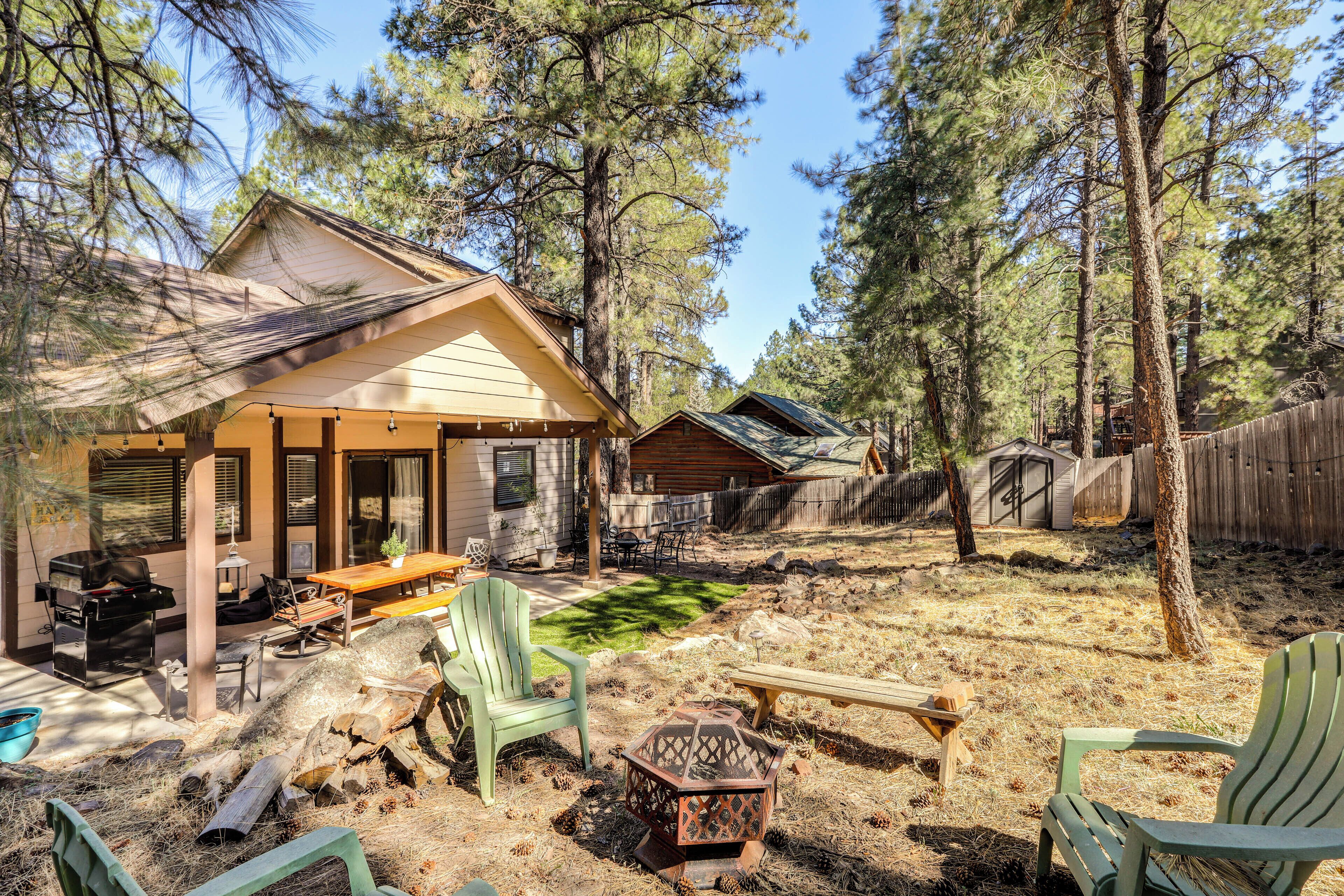 Une cabane dotée d’un patio couvert, de meubles d’extérieur et d’un foyer.