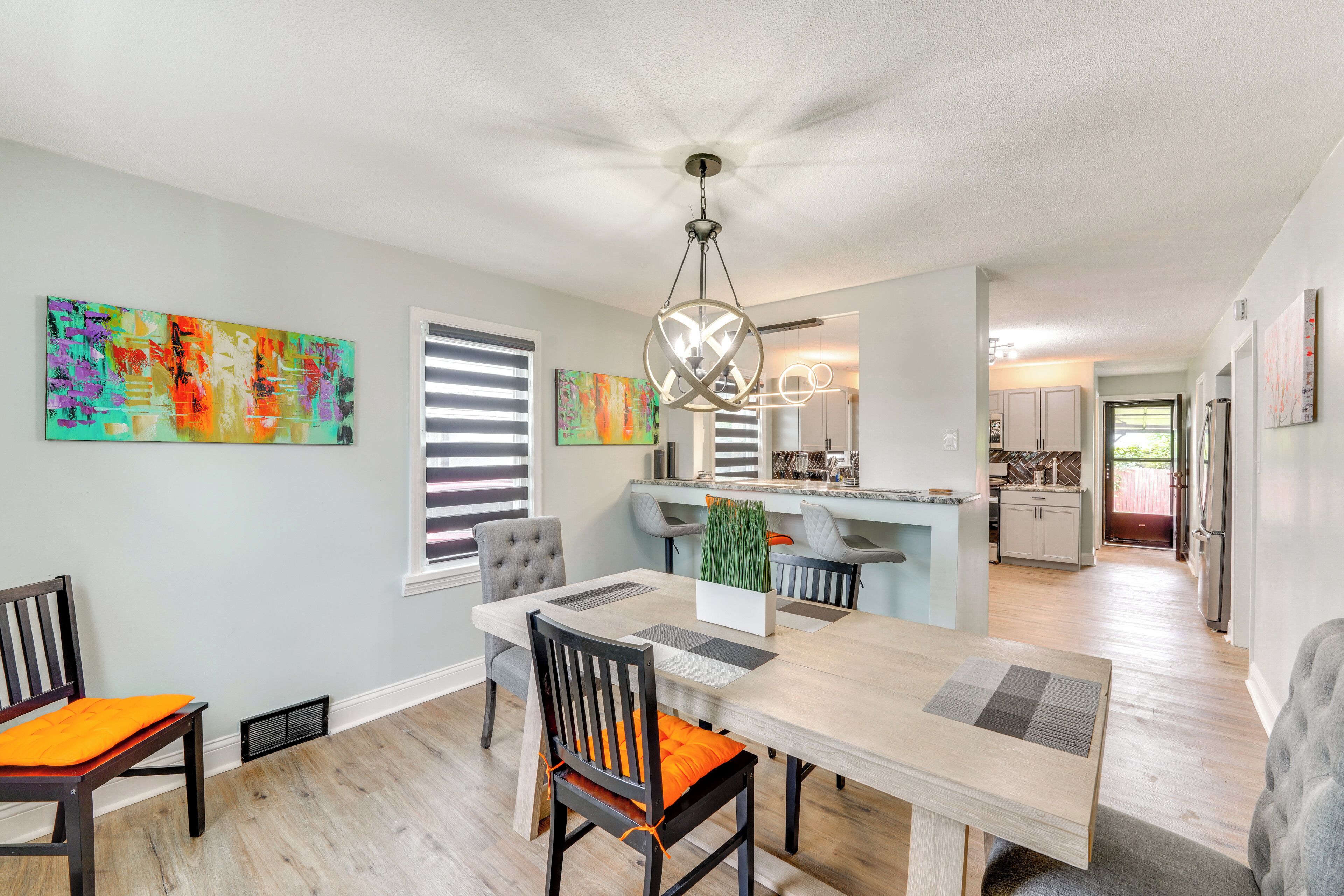 A modern dining area with a wooden table, chairs, and a ceiling fan.