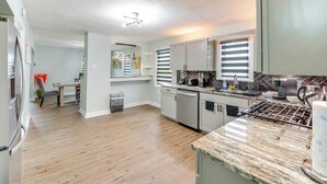 A modern kitchen with a stainless steel refrigerator, a dishwasher, a stove, and a countertop with a paper towel dispenser.