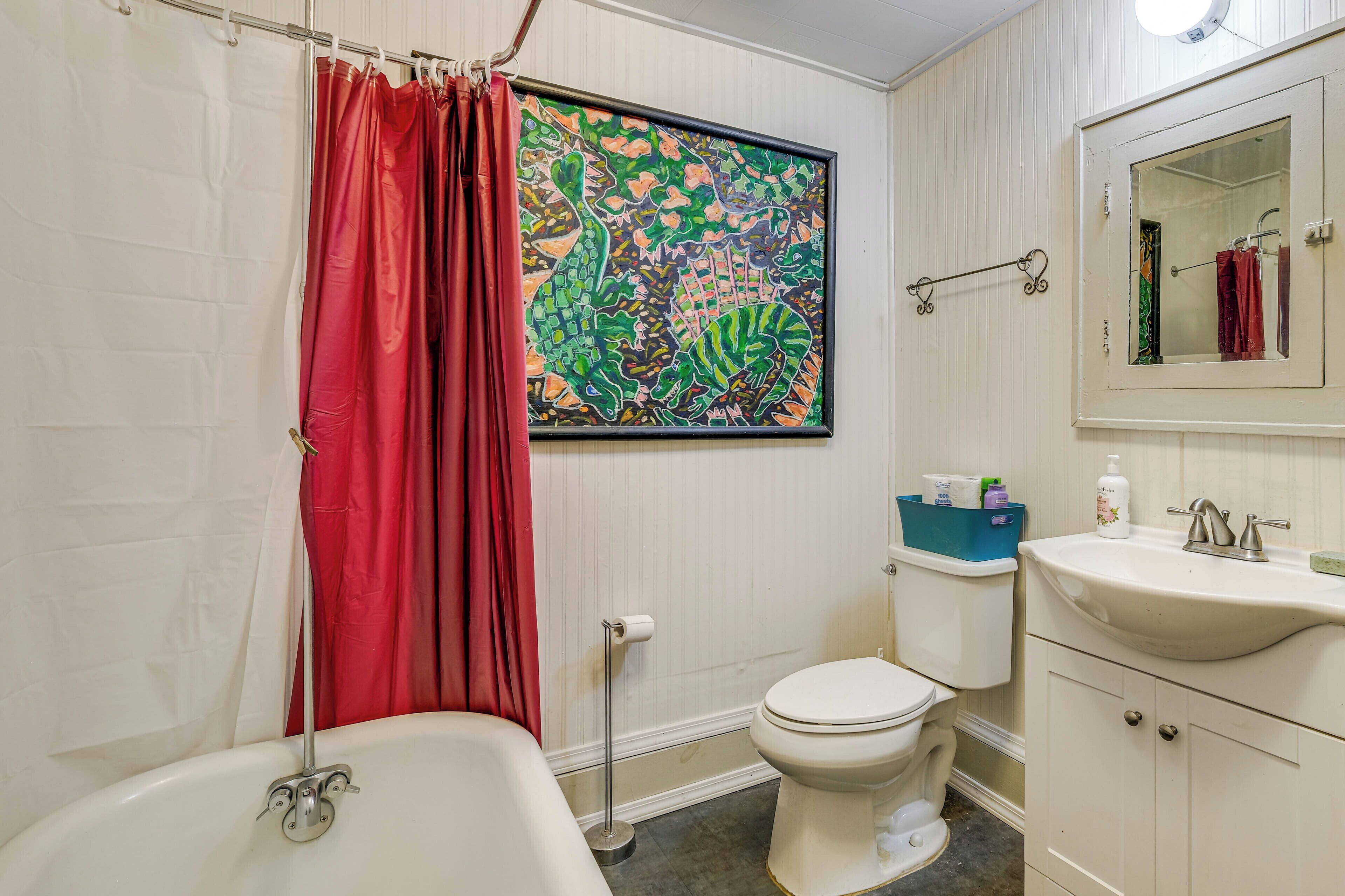 Et badeværelse med badekar, toilet og håndvask.