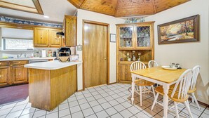 Une cuisine avec des meubles en bois, un îlot central et une table à manger avec des chaises.