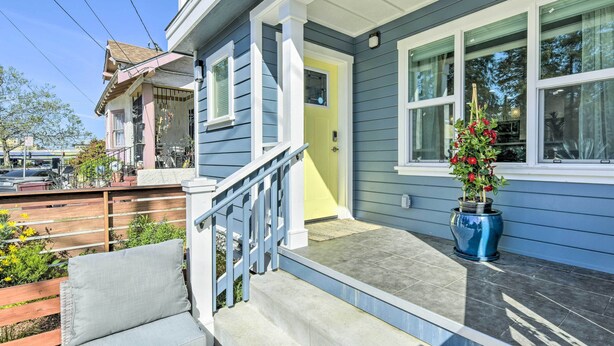 A two-story house with a front porch, a yellow door, and a blue flower pot. - Sunny Oakland Retreat w/ Patio & Cute Garden! (Oakland)