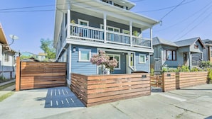 A two-story house with a balcony, a gated driveway, and a satellite dish. - Sunny Oakland Retreat w/ Patio & Cute Garden! (Oakland)