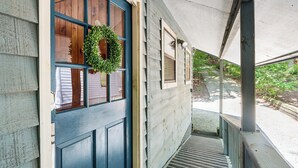 A blue door with a wreath, a covered porch, and a wooden exterior. - Cartecay River Retreat w/ Yard & Screened Porch! (Ellijay)