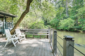 A wooden deck with white chairs and a railing overlooking a river. - Cartecay River Retreat w/ Yard & Screened Porch! (Ellijay)