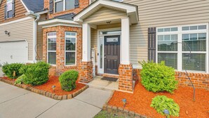 A two-story house with a brick facade, a front porch, and a garage.