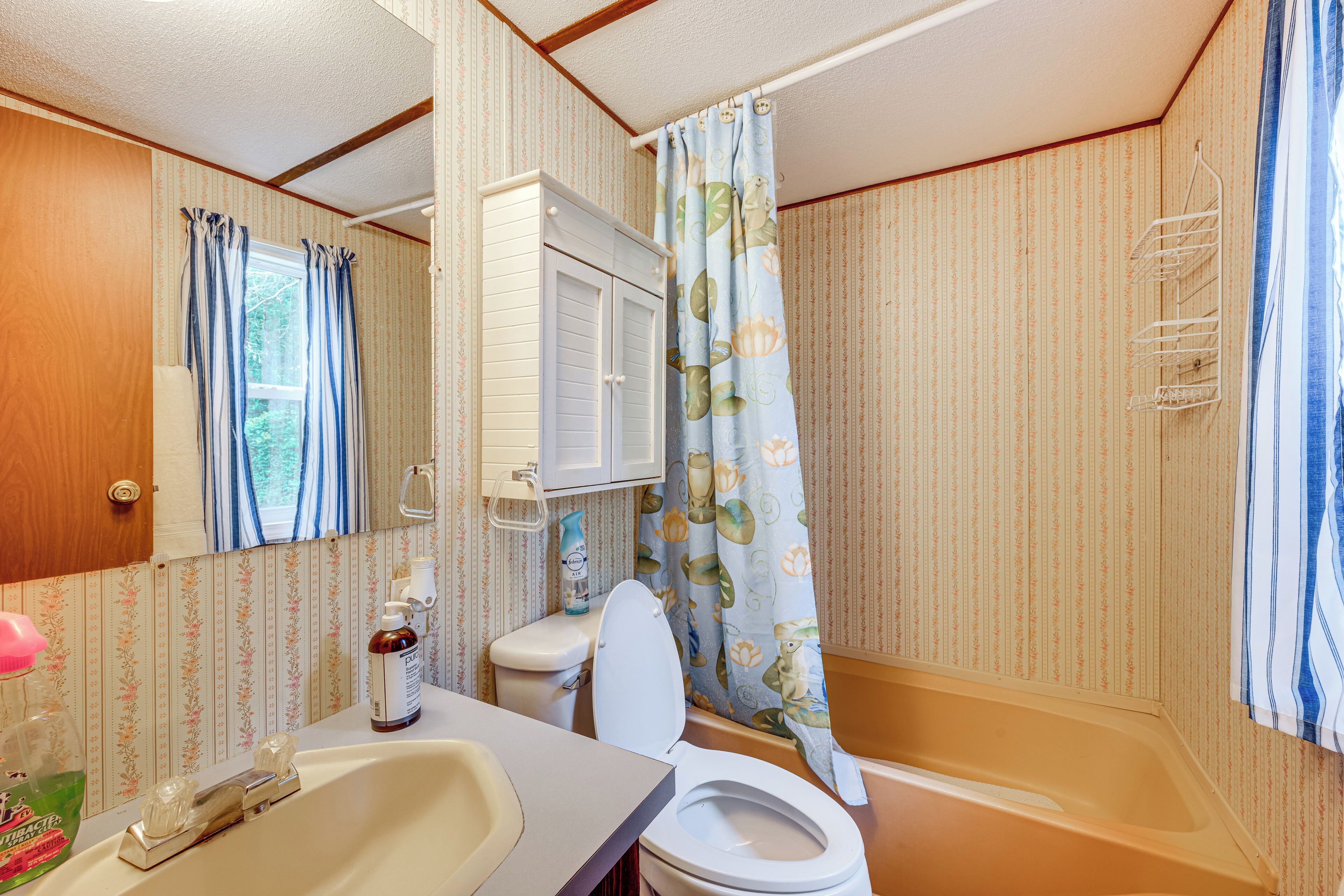 A compact bathroom with a toilet, sink, and bathtub.