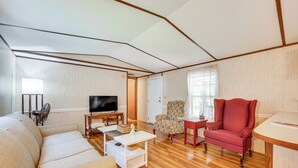 A living room with a sofa, armchair, TV, and coffee table. - 5 Min Walk to Badin Lake: 3BD Home w/ Deck & BBQ (New London)