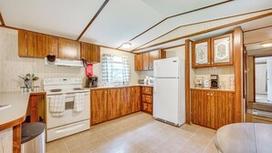 A kitchen with wooden cabinets, a white stove, and a refrigerator. - 5 Min Walk to Badin Lake: 3BD Home w/ Deck & BBQ (New London)