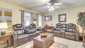 A living room with two leather sofas, a coffee table, a TV stand, and a ceiling fan. - 4 Mi to Old Town: Pet-friendly Home w/ Fenced Yard (Albuquerque)