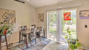 Un coin repas avec une table et des chaises, une plante en pot et des œuvres d’art accrochées aux murs.