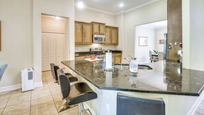 A modern kitchen with a large island, built-in appliances, and a seating area. - Family Home < 10 Mi to Flagler Beach: WFH Ready! (Palm Coast)