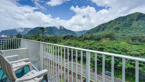 Ein Balkon mit Pool, eine Straße und eine gebirgige Landschaft.