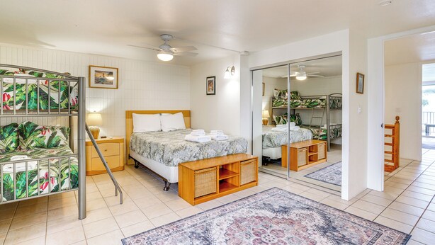 Ein Schlafzimmer mit Bett, Nachttischen, einem Spiegel und einem Kleiderschrank.