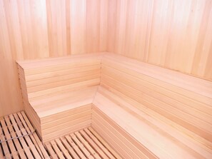 Una sauna con bancos de madera y suelo inclinado.