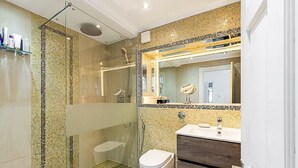 A modern bathroom with a glass-enclosed shower, a white toilet, and a vanity with a mirror. - Chic Marylebone Central Flat (London)