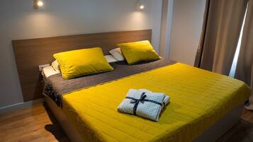 A bed with a wooden headboard, two pillows, and a yellow bedspread.