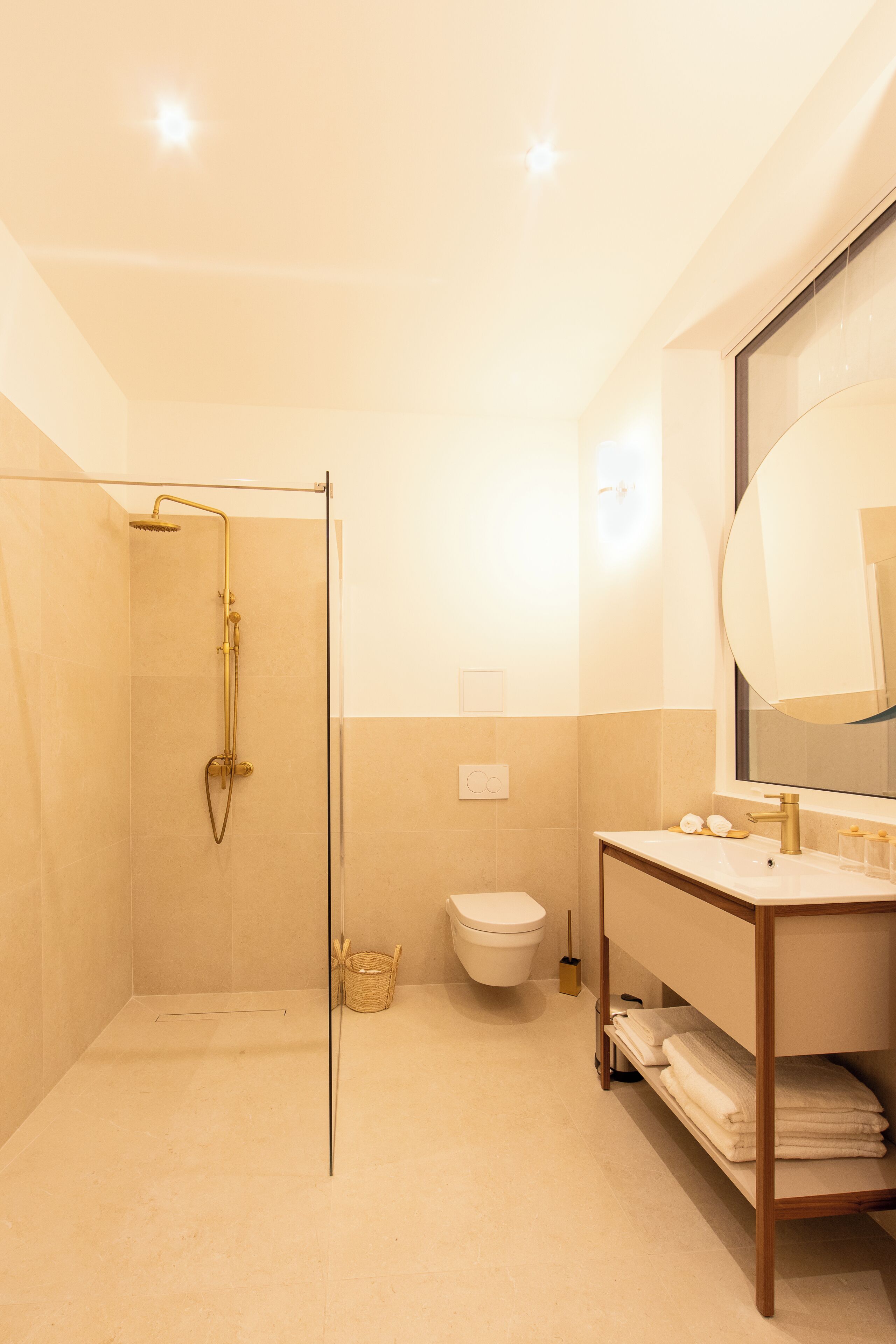 A modern bathroom with a glass-enclosed shower, a toilet, and a vanity with a mirror.