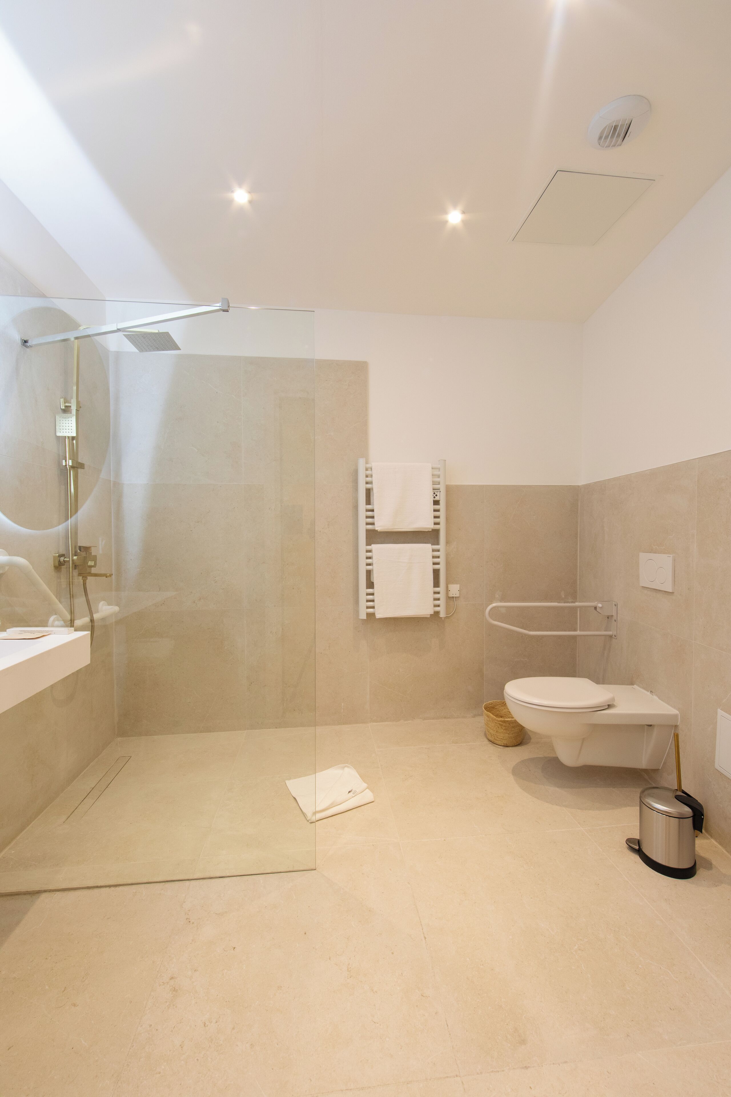 Un baño moderno con ducha acristalada, inodoro y lavamanos.