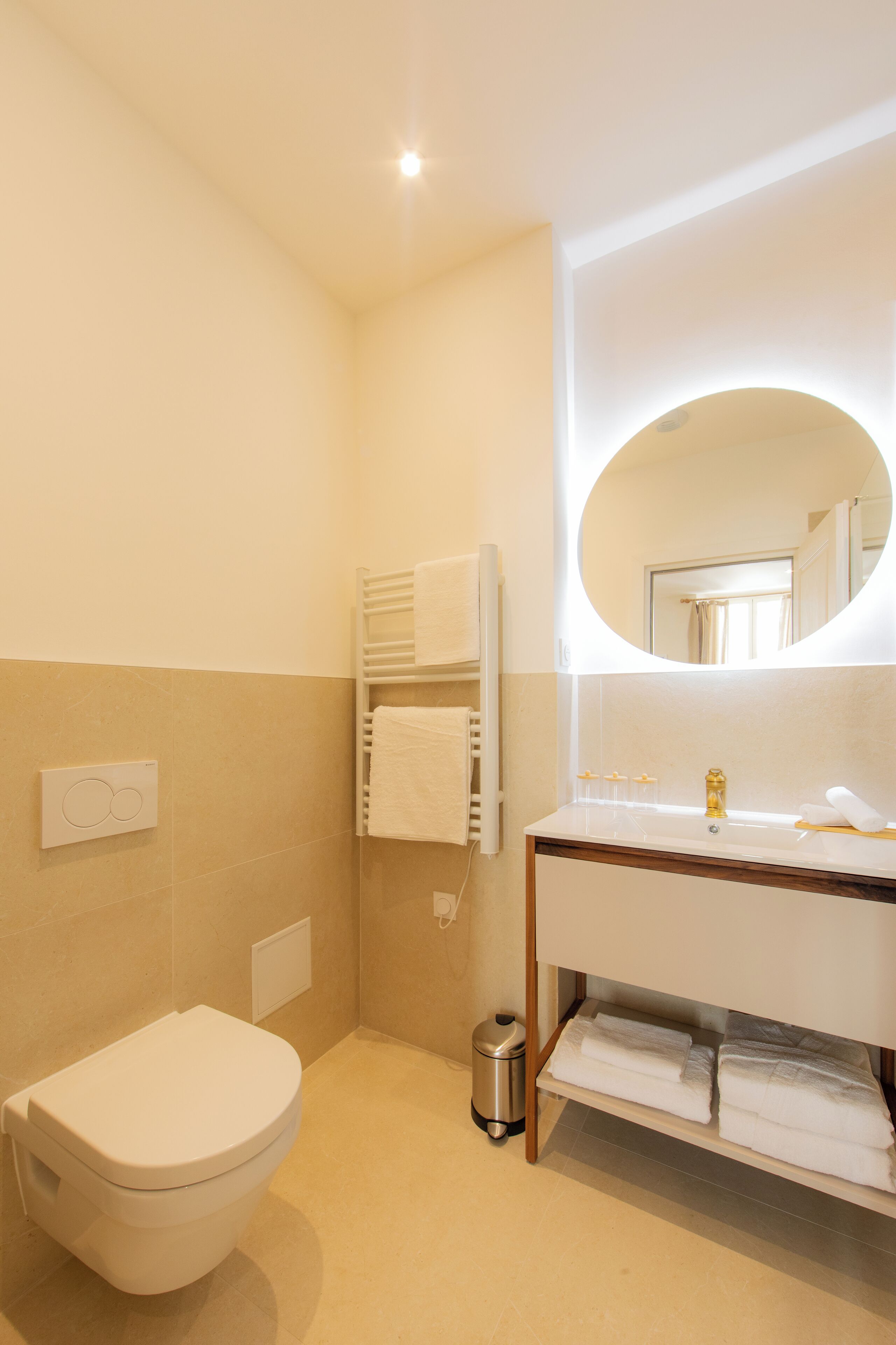Een moderne badkamer met toilet, wastafel en spiegel.