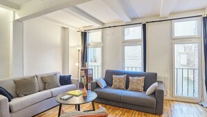 A living room with two sofas, a coffee table, and a bookshelf. - Magnificent Flat in Saint Germain des Pres (Paris)