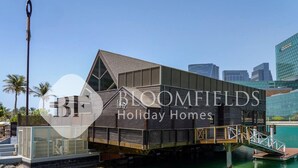 Een modern vakantiehuis met een uniek drijvend ontwerp, met een ruim balkon en uitzicht op het water.