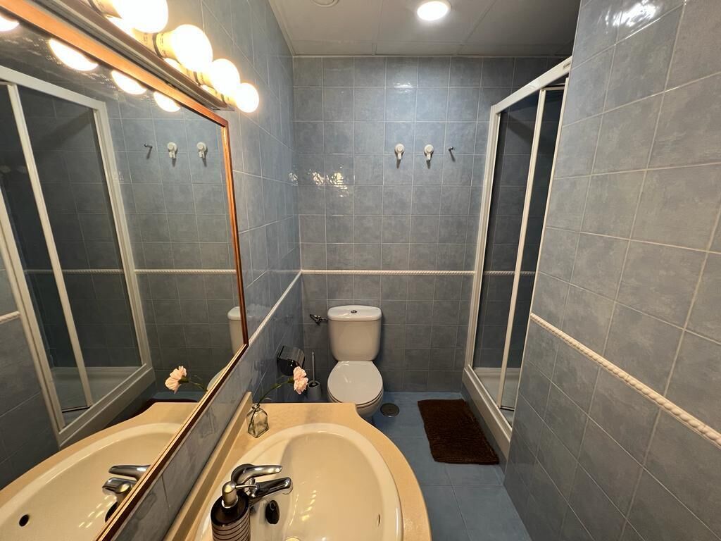 Et badeværelse med badekar, vask, toilet og bruseniche.