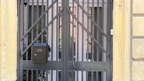 Une porte métallique équipée d’une caméra de surveillance et d’une boîte aux lettres.