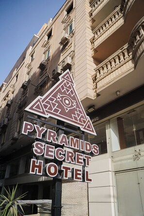 A sign for the Pyramids Secret Hotel with a geometric design. - Pyramids Secret Hotel (Giza)