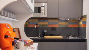 Eine moderne Küche mit Mikrowelle, Herd und Kaffeemaschine.