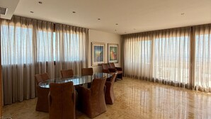 A spacious conference room with a glass table and brown leather chairs, large windows with curtains, and a marble floor. - Holiday Home 'Marbella Hills' with Sea View, Wi-Fi and Air Conditioning (Marbella)