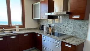 A kitchen with granite countertops, stainless steel appliances, wooden cabinets, and a window with a view. - Holiday Home 'Marbella Hills' with Sea View, Wi-Fi and Air Conditioning (Marbella)