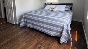Une chambre à coucher avec un lit, un ventilateur de plafond, une fenêtre et une porte.