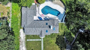 An aerial view of a house with a swimming pool, a covered patio, and a well-maintained lawn. - Hyannis Hideaway: Pool, Beaches & Main Street Fun RPAM114 (Hyannis)