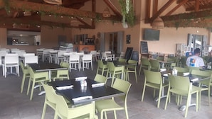 A spacious outdoor dining area with multiple tables and chairs, a counter with a menu board, and hanging plants. - Mobilhome des gorges du verdon (Montagnac-Montpezat)