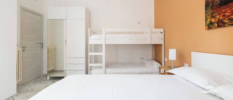 Un dormitorio con literas, un armario y un radiador.
